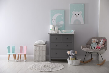Chest of drawers with changing tray and pad in baby room. Interior design