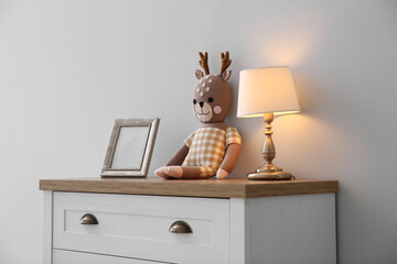 Modern white chest of drawers near light wall in child room. Interior design