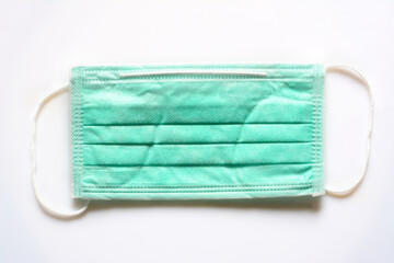 Fototapeta premium Medical mask on white background. Aquamarine protective mask for Covid-2019 and coronovirus protection. Close up protective mask with textile filter.