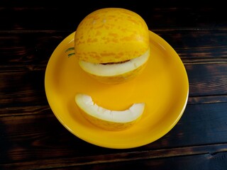 Fresh melon. Slices of melon on a black wooden table. top view.