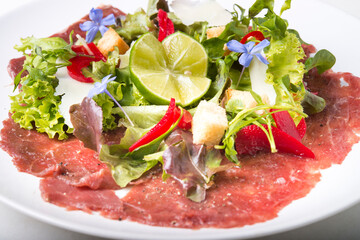 Beef Carpaccio with salad and lime on top