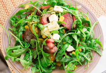 mixed salad of arugula and fresh vegetables with sauce