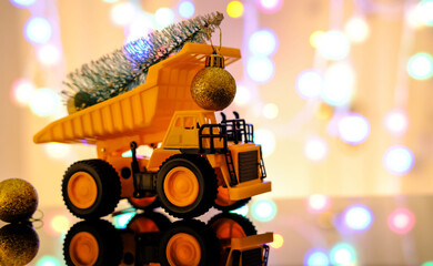 Children's truck carries a Christmas tree. Christmas card. Light blurred background