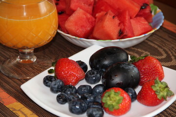 Bright juicy summer fruits and a glass of orange juice