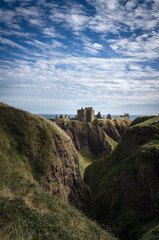 Fototapeta na wymiar Dunnottar Castle on top of a cliff by the sea on a cloudy day, Stonehaven, Scotland, United Kingdom