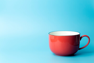 Colored cup on an empty colored background, minimal concept background. Home cookware and morning idea