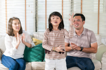 Asian family doing activity  together in the house a doughter practice dancing showing her parent