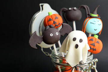 Obraz premium Delicious Halloween themed cake pops on black background, closeup
