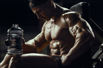 Fototapeta na wymiar Bodybuilder with protein powder supplements jar