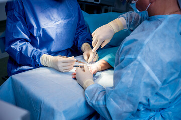 Surgeons in the operating room trying to save the patient's hand.