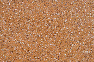 Beautiful facade mosaic plaster, light brown with white and dark splashes.