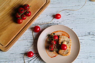Naklejka na ściany i meble pork steak, grilled and served with cherry tomatoes on white wood table