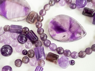 Natural amethysts of different sizes on a white background