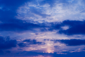 Night blue sky and moonlight background. The magic moon shines in the night sky through dark blue clouds.