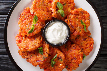 Tomatokeftedes are fried tomato balls served as an appetizer on the Greek island of Santorini close-up in a plate on the table. Horizontal top view from above