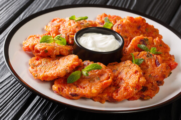 Greek tomato fritters served with yogurt close up in a dish on the table. horizontal