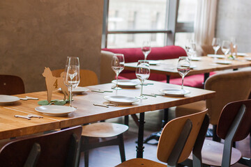 A wooden table by the window in the restaurant is served with dishes