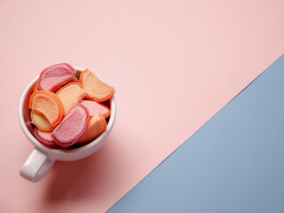 dessert fruit jelly candy in cup on color pastel two tone background copy space