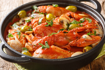 Chicken marengo is a hearty, but bright, simmered dish, full of mushrooms, crayfish, tomatoes, garlic and white wine close-up on the table. Horizonta