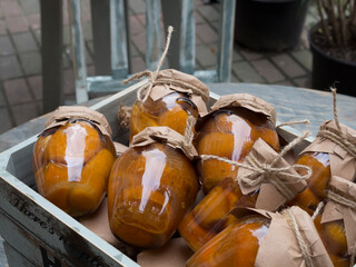 Glass jars with orange jam lie in a wooden box