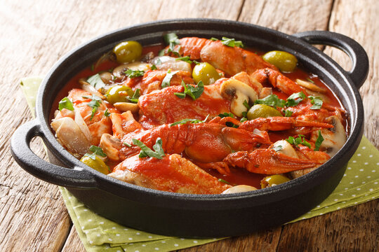 French food Chicken Marengo with crayfish, mushrooms, olives, tomatoes and shallots close-up on the table. horizontal