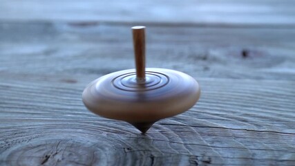 Spinning totem or whirligig in slow motion on a wooden table
