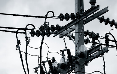 Black and white scene of three-phase electric power for transfer power by electrical grids. Electric power for support manufacturing industry. High voltage electric poles and wire lines.
