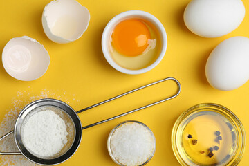 Flat lay composition with chicken eggs on yellow background