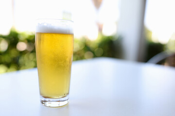 Glass alcoholic beer is on table in bar. Summer beach parties concept.