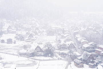 Fototapeta na wymiar Gassho-zukuri houses on Shirakawago villages with snowfall in Gokayama Village from hill view point in snowing fall winter. Shirakawa-go has been inscribed on UNESCO World Heritage, Gifu Prefecture