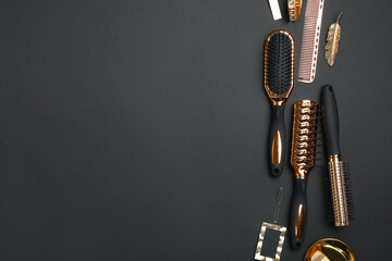 Flat lay composition with modern hair brushes on black background. Space for text