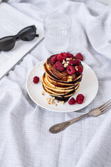Tasty Pancakes. Stack of pancakes topped with chocolate and raspberry. Breakfast