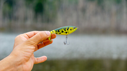 fishing lure held in hand,a fishing lure is a type of artificial fishing bait used to attract fish. Lures come in many different shapes, sizes, and colors, each designed to attract fish