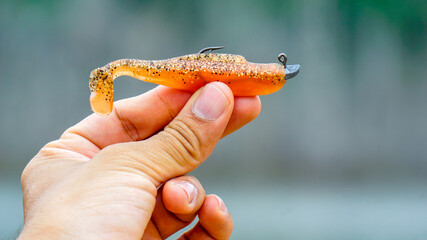 fishing lure held in hand,a fishing lure is a type of artificial fishing bait used to attract fish. Lures come in many different shapes, sizes, and colors, each designed to attract fish