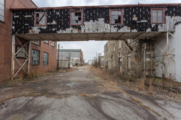 Fototapeta premium Decaying walkway over empty entrance to an abandoned factory in the deep south