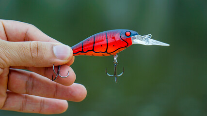 fishing lure held in hand,a fishing lure is a type of artificial fishing bait used to attract fish. Lures come in many different shapes, sizes, and colors, each designed to attract fish