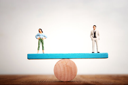 Concept image of gender equality. man and woman balancing on seesaw