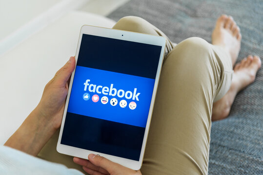 Uzhgorod, Ukraine - September 6, 2020: Woman Hands Using IPad With Facebook Homepage On Screen. Facebook The Biggest Social Network Website.