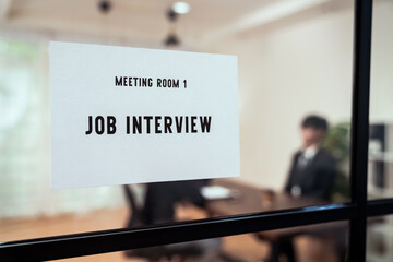 Interview sign in front of the meeting room. Business people sit at a table and wait for company Human Resource(HR).