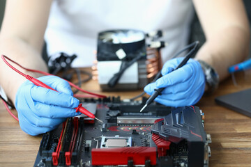 Gloved master holds microcircuit probe in his hands. Chip service concept