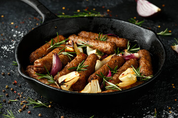 Rosemary and onion vegetarian vegan sausages oven baked in cast iron skillet frying pan