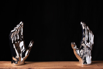 Surreal silver hands on a black background 
