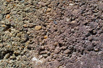 Old concrete wall with round gravel pebbles for background texture