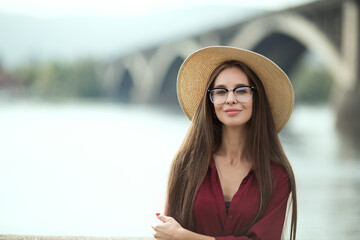 Portrait of an urban woman in a hat and glasses. Long brown hair. Smart young student. Style and fashion