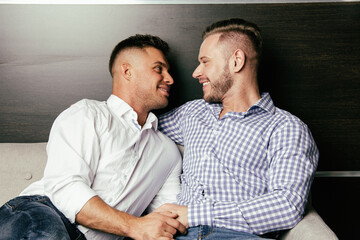 Young attractive gay couple at home.