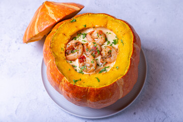 Pumpkin stuffed with shrimps and cheese, whole baked. Traditional Brazilian dish. Close-up.