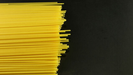 Yellow long spaghetti on black background