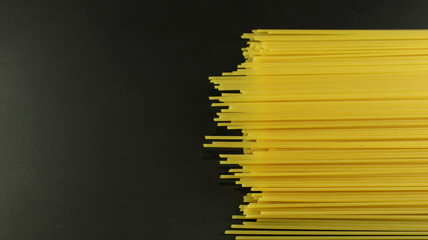 Yellow long spaghetti on black background