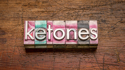 ketones word abstract in gritty vintage letterpress metal type stained by printing ink against rustic wood, keto diet concept