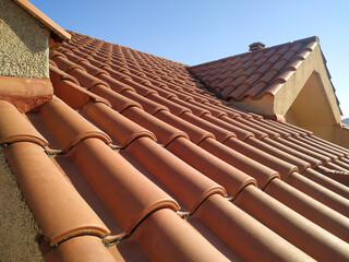 Tiles on the roof of a residential building attic over blue sky